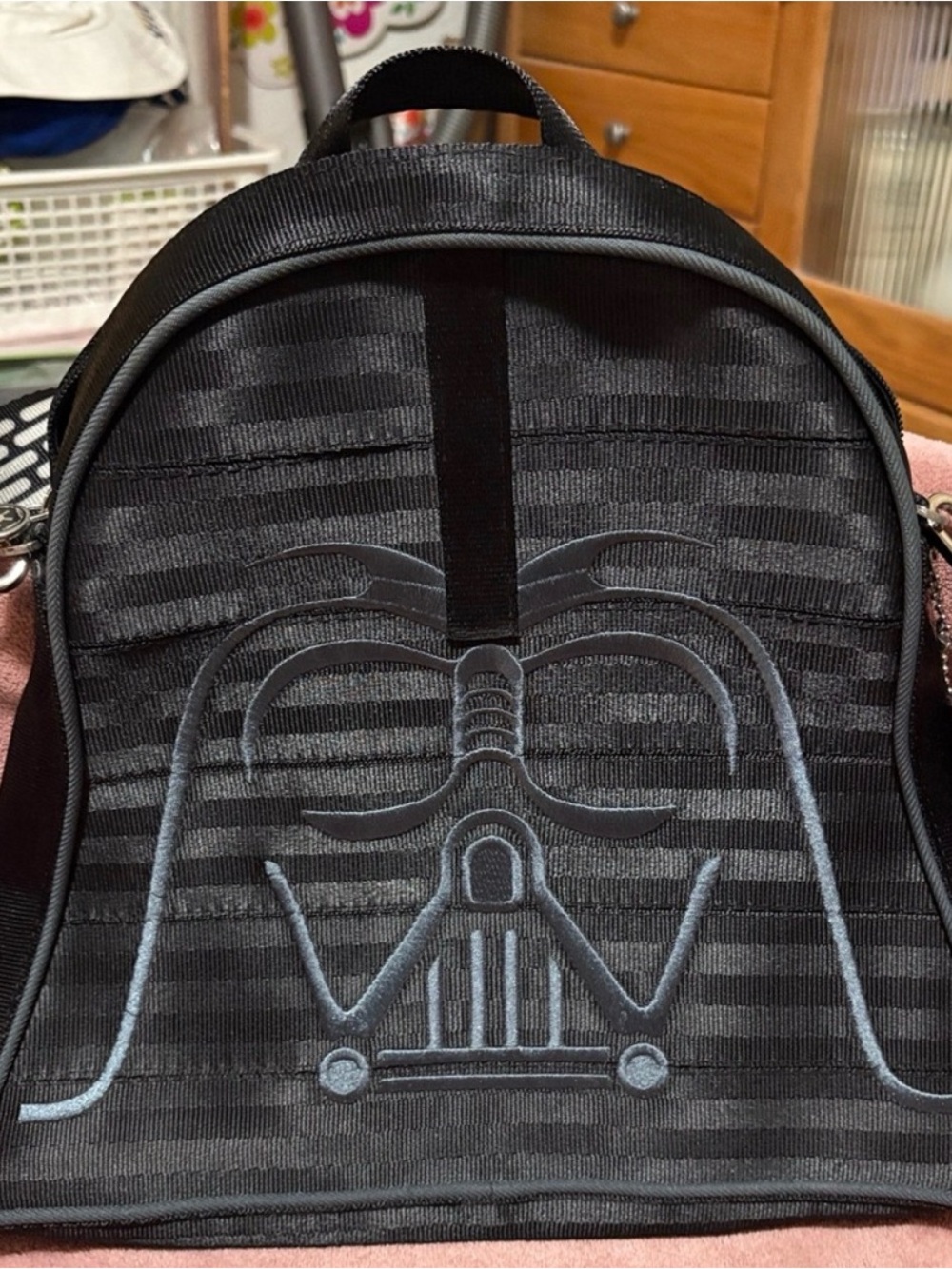 Black Mini Backpack with Embossed Sci‑Fi Mask Detail